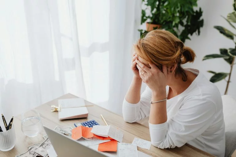 woman at a desk with her head in her hands